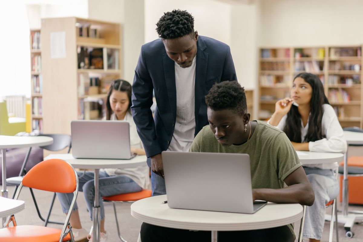 Estudiantes trabajando con portátiles en un aula